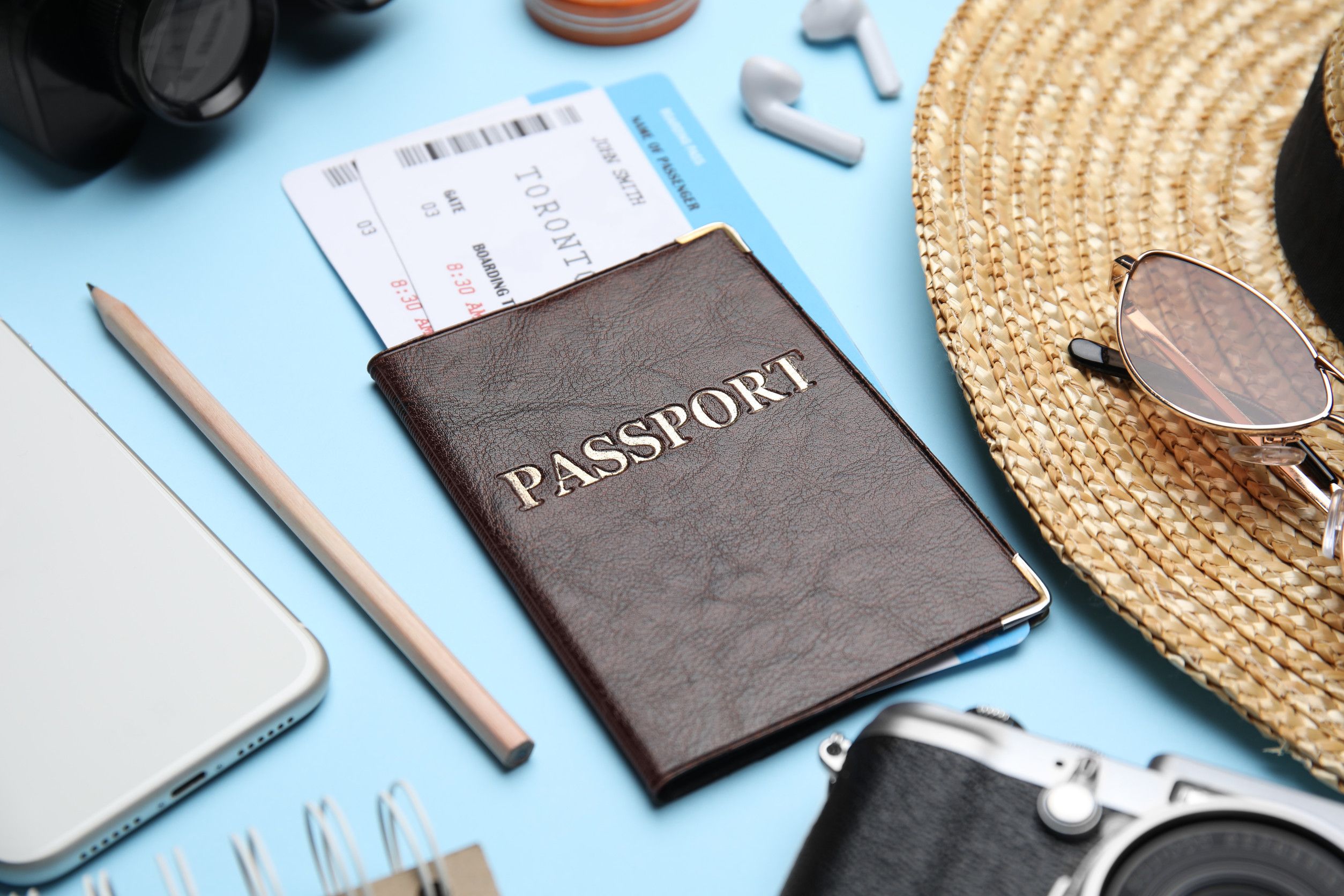 Passport with travel essentials laid out Passport with travel essentials laid out