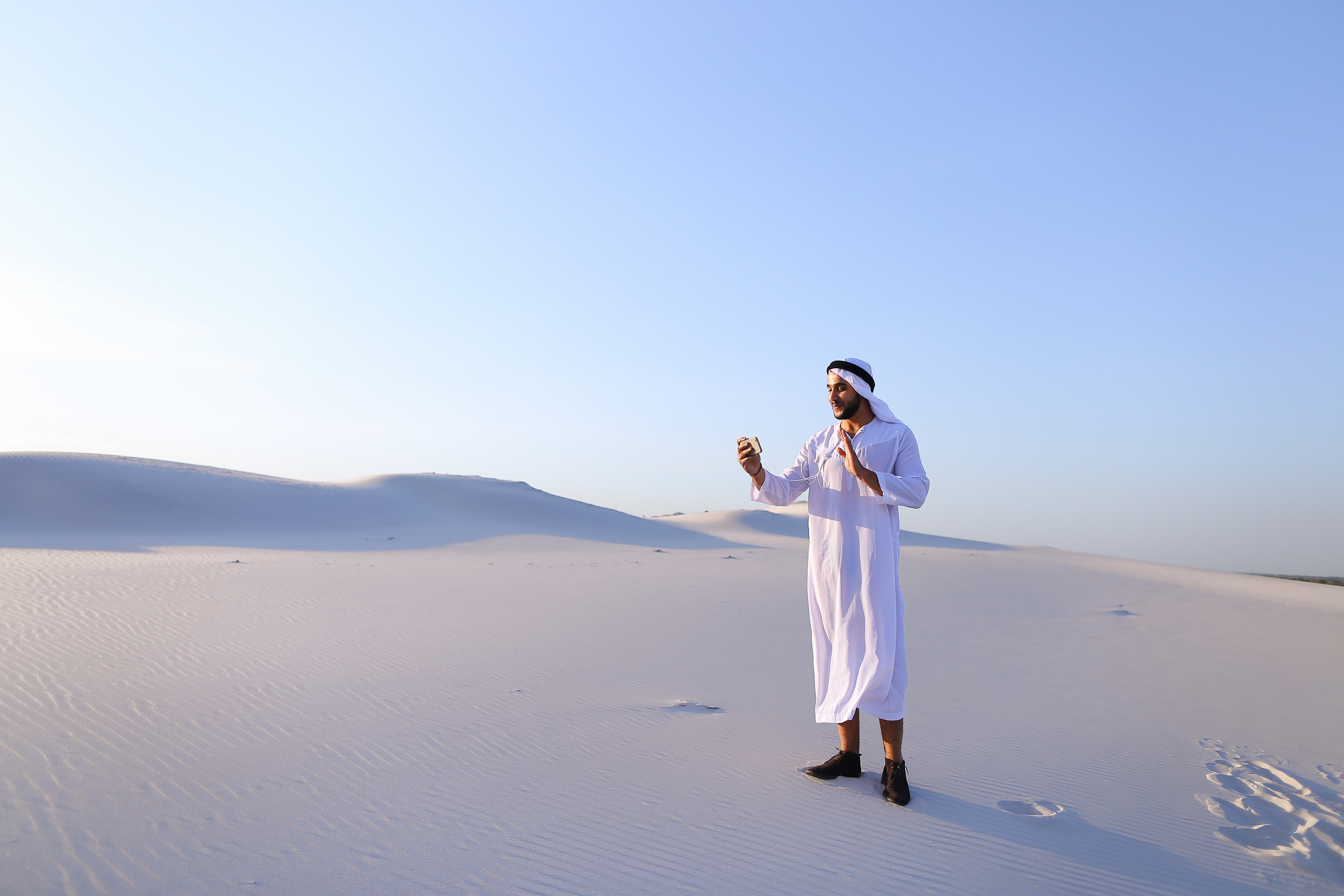 Moderner gutaussehender muslimischer Mann mit Telefon Moderner gutaussehender muslimischer Mann mit Telefon