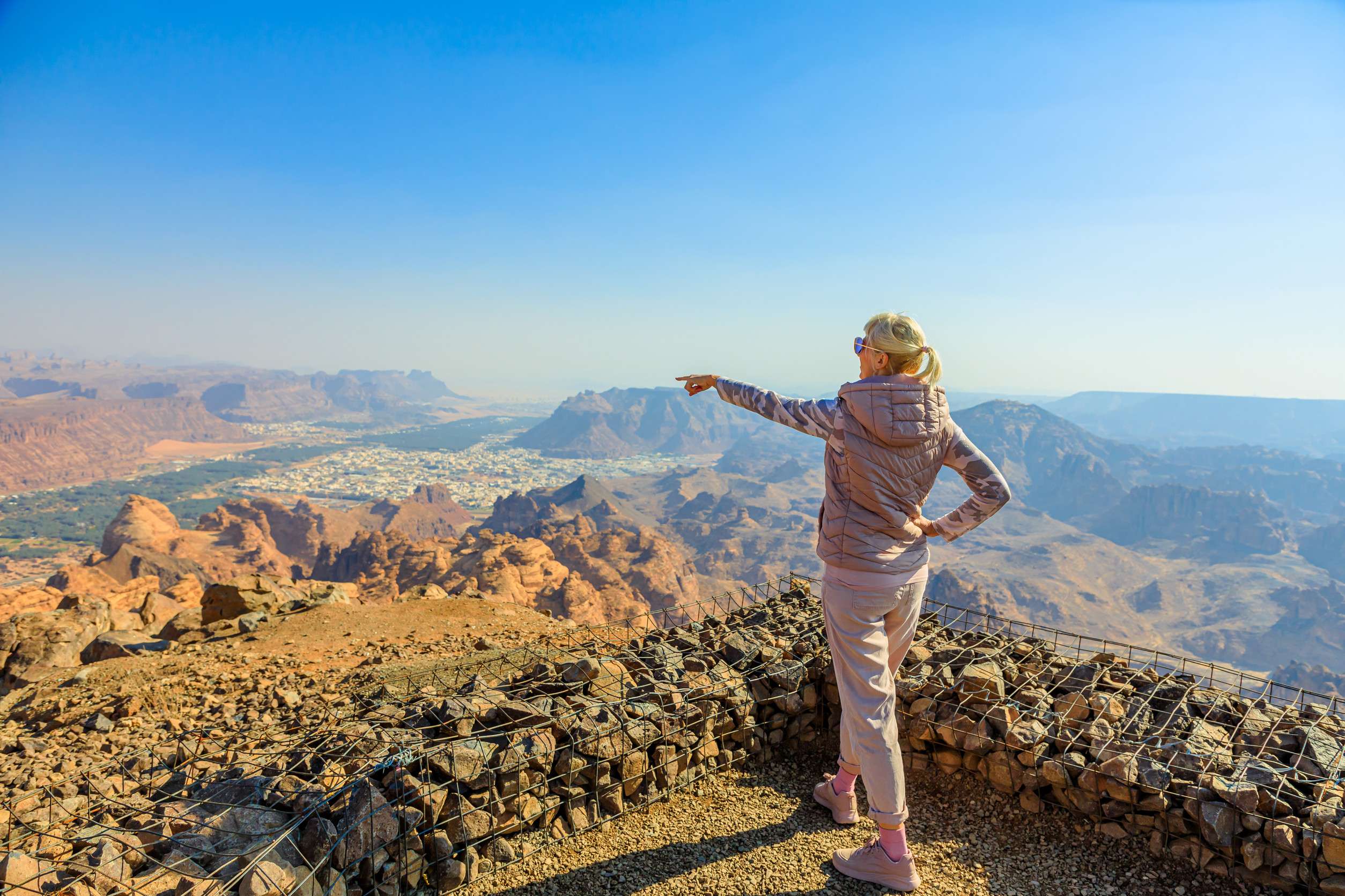 Tourist Pointing At Alula Old Town From The Harrat Viewpoint Enjoying Breathtaking Panoramic Tourist Pointing At Alula Old Town From The Harrat Viewpoint Enjoying Breathtaking Panoramic