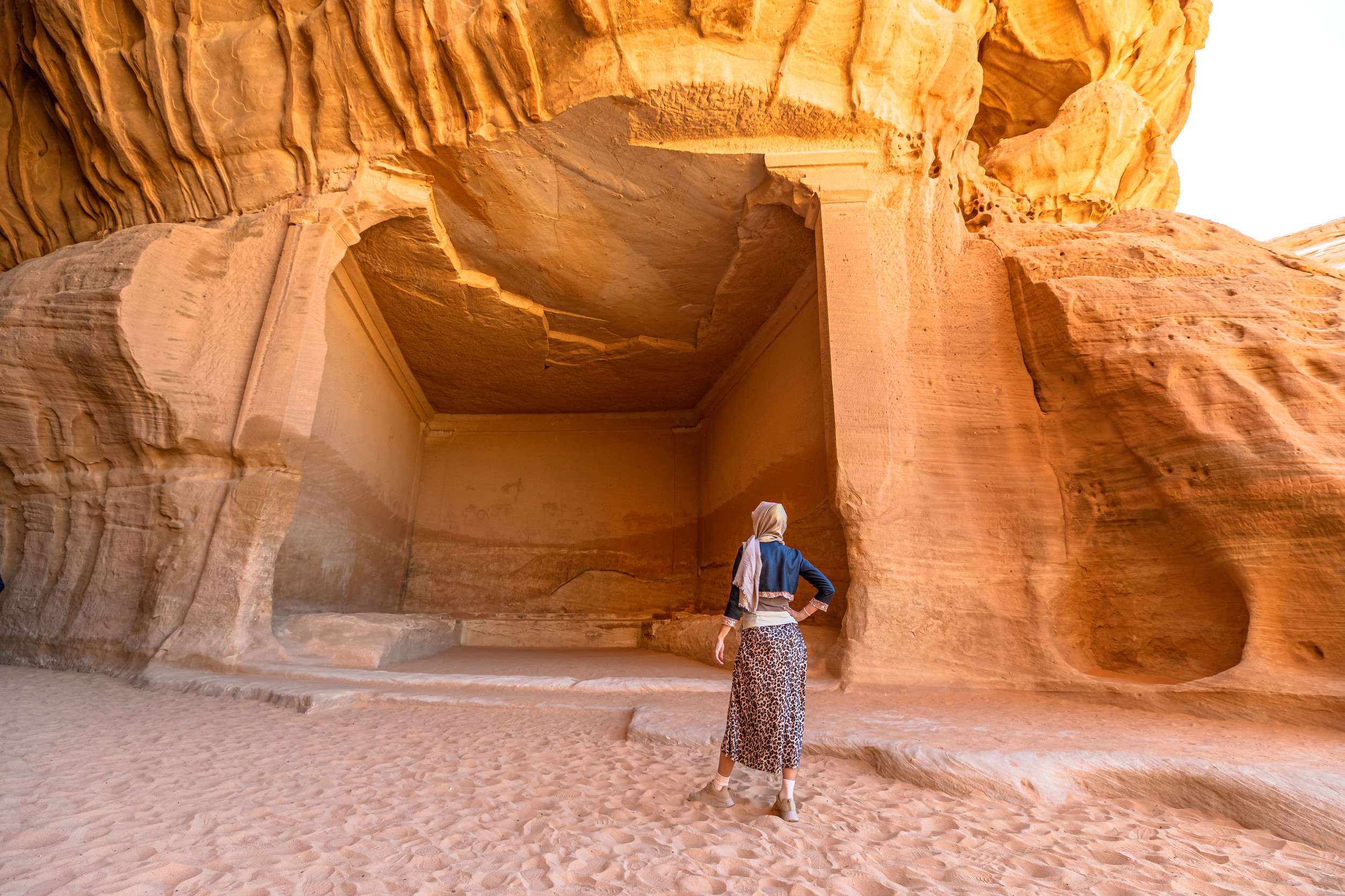 Woman Admiring Jabal Ithlib Rock Cut Tombs In Archaeological Site Of Hegra The Diwan And Siq Woman Admiring Jabal Ithlib Rock Cut Tombs In Archaeological Site Of Hegra The Diwan And Siq