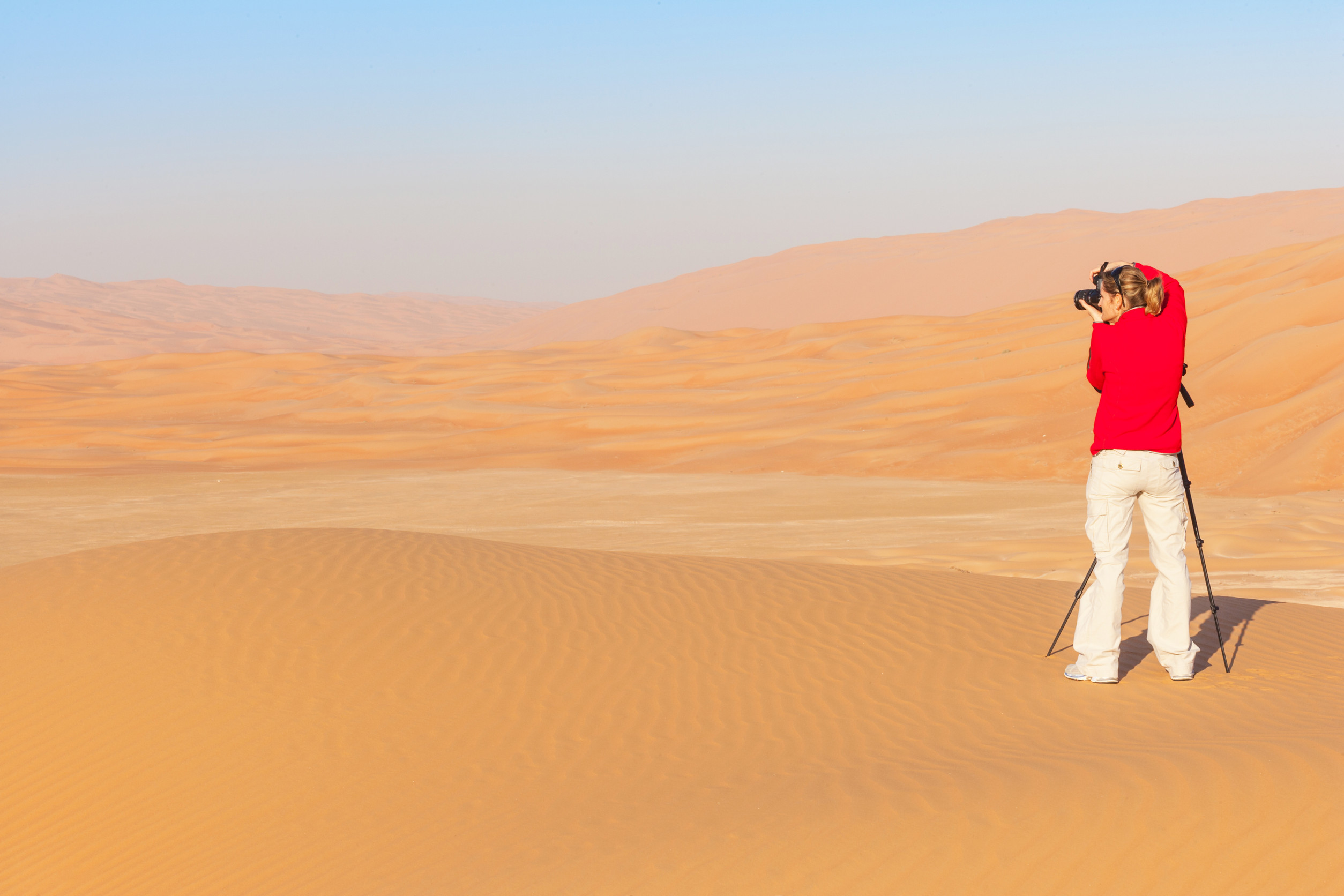 Woman Photographing Sand Dunes In The Rub Al Khali Or Empty Quarter Straddling Oman Saudi Arabia Woman Photographing Sand Dunes In The Rub Al Khali Or Empty Quarter Straddling Oman Saudi Arabia